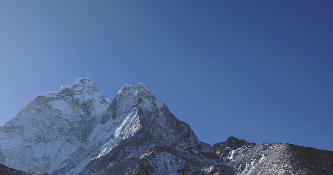 Snow Mountain Rock Peak with Moving clouds 4K Timelapse Video Nature Background abstract. Hiking Trekking Climbing Tourism to Everest in Nepal