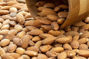 Almonds spilling out of wooden  bowl