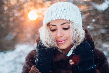 Close-up portrait of beautiful young afro american woman in winter forest on sunset