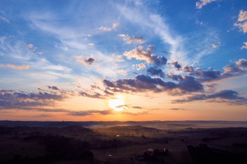 Aerial view of a sunset with sunbeams from forest. Countryside view. Fantastic landscape. Great colors and contrast
