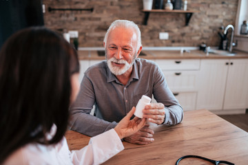 Senior patient talking with a female doctor about medicine.