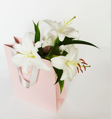 a bouquet of white lilies in a pink package 