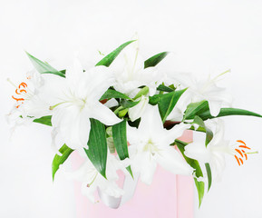 a bouquet of white lilies in a pink package 