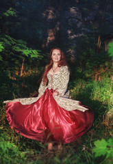 Fototapeta premium Beautiful happy woman in long medieval dress dancing