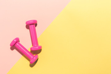 Dumbbells flat lay on pink and yellow