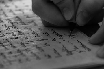 Close-Up Of Hand Writing On Paper
