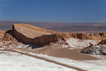 Dunes and rock formations covered with dry salt in Valle de la Luna, Atacama, Chile