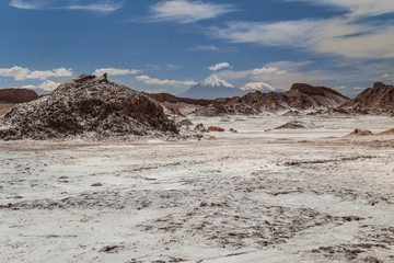 Rock formations covered with salt, volacanos on the background.  Valle de la Luna, Atacama, Chile