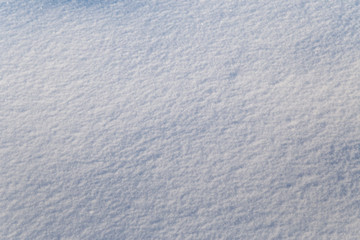 Background of white snow sparkling in the sun. Shallow depth of field