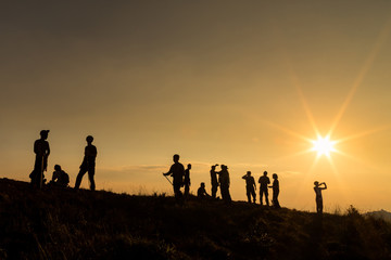 Silhouette tourists on top mountain. Tourist watching the beautiful sunset sky on top of a mountain. Travel concept.