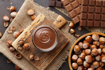 Chocolate spread, nuts and chocolate bars on table