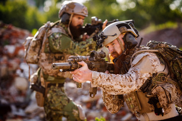 rangers with assault rifles on battlefield background. army, military and people concep