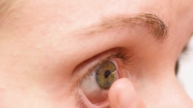 Girl puts on a contact lens for sight on the eye.