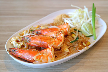 Closed Up Delectable River Prawns Topped on Pad Thai or Thai Style Fried Noodle Served on Wooden Table 