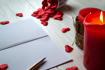 Red candles, love hearts and notebook on the table. Beautiful bckground with copy space.