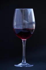 Fotobehang Crystal clear wine glass with traditional round goblet shape filled with dark red wine. © elenakibrik