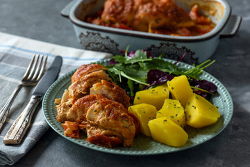 Oven-baked chicken breast with mozzarella and tomatoes, served with potatoes.