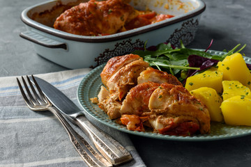 Oven-baked chicken breast with mozzarella and tomatoes, served with potatoes.