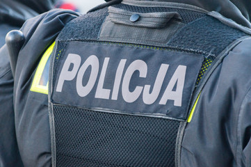 Back of polish policeman and inscription policja