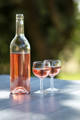 two glasses and a bottle of rose wine