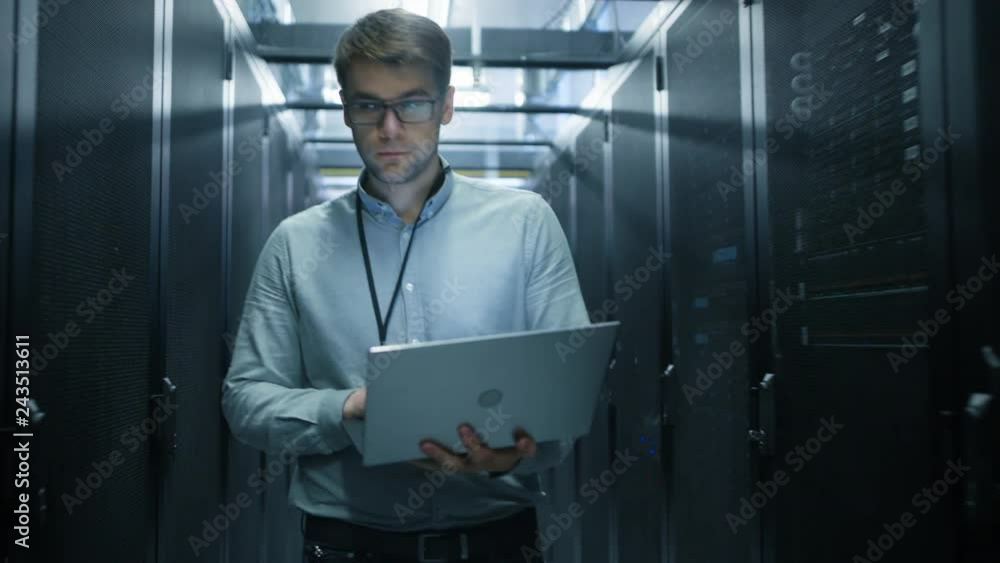 Fototapete Walking Through Data Center IT Engineer Stops Before Working Server Rack to Do Routine Maintenance Check Using Laptop. Concept of Cloud Computing, Artificial Intelligence, Supercomputer