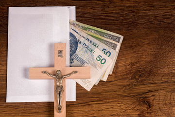 A crucifix lying on an envelope with Polish banknotes