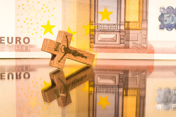 The crucifix on the background of the euro banknote