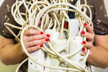 Woman with old and unsafe electrical extension strip cords