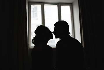 Romantic silhouettes of a couple in love against the window