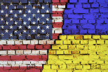 Flags of United States of America and Ukraine on the brick wall with big crack in the middle....