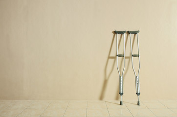 crutches against a wall with shadow and copy space.
