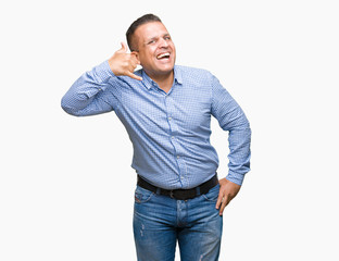 Middle age arab business man over isolated background smiling doing phone gesture with hand and fingers like talking on the telephone. Communicating concepts.