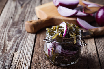 Obraz na płótnie Canvas Seaweed salad with red onion in glass jar, healthy sustainable food