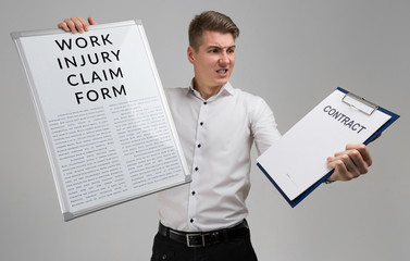 young man holding a form with a claim of injury at work and blank contract form isolated on a light background