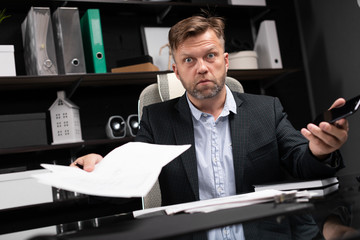 young man in business clothes working at computer Desk with phone and documents