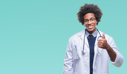 Afro american doctor man over isolated background doing happy thumbs up gesture with hand. Approving expression looking at the camera with showing success.