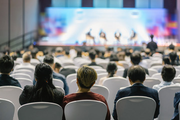Rear view of Audience listening Speakers on the stage in the conference hall or seminar meeting,...