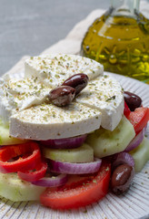 Traditional greek salad made with fresh cucumber, tomato, paprika, red onion, kalamata olives, white salted feta cheese with oregano served with olive oil