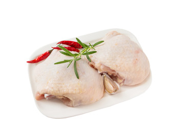 Raw chicken thighs with rosemary  on cutting board, on a white background.