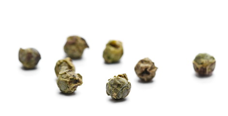 Dry green pepper pile, macro peppercorn isolated on white