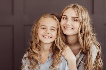 Happy sisters hugging and looking at camera