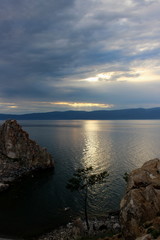 Dark landscape of the last colors of the evening on Cape Burkhan at the Olkhon Island on Baikal lake. Summer vacation in the heart of Siberia. The sacred place of Buddhists and shamans. Small sea