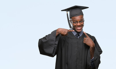 Young graduated african american man over isolated background smiling confident showing and pointing with fingers teeth and mouth. Health concept.
