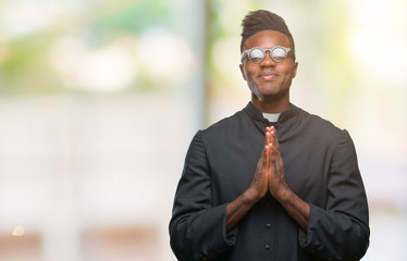 Young african american priest man over isolated background praying with hands together asking for...