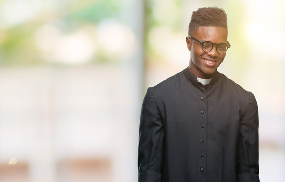 Young african american priest man over isolated background winking looking at the camera with sexy expression, cheerful and happy face.