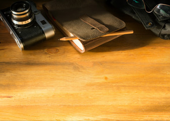 traveler blog background; vintage camera and notebook on old office desk