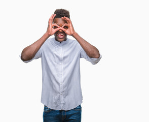 Young african american man over isolated background doing ok gesture like binoculars sticking tongue out, eyes looking through fingers. Crazy expression.