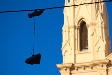 Obraz premium shoes hanging by a thread in an urban landscape