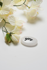 Obraz na płótnie Canvas White flowers with a stone that depicts joy.