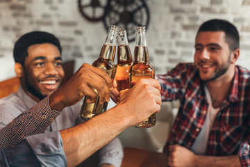 Friends clinking bottles of beer, celebrate meeting